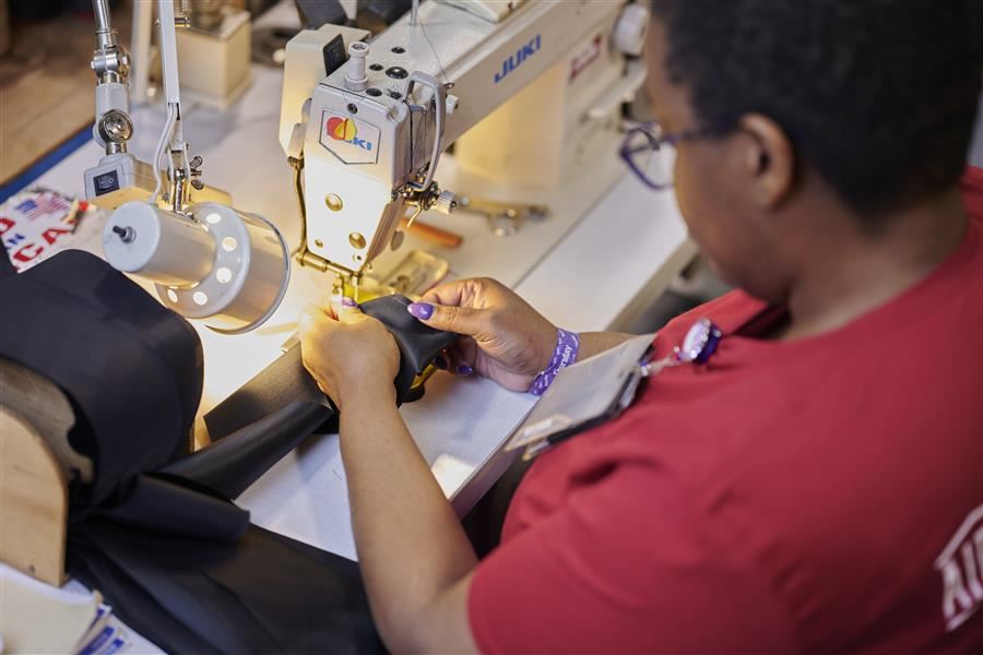 A woman sewing a tie for the military. 